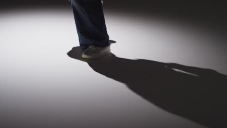 toma de estudio de cerca que muestra los pies de una mujer bailando con iluminación de bajo tono contra un fondo gris 5