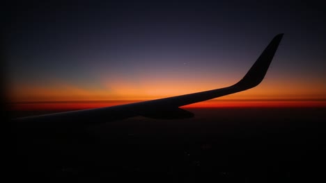 airplane wing with a sunrise in background and beautiful sky