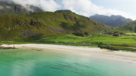 imágenes giratorias de drones de la playa de vik y hauklandstranda noruega, costas nórdicas aéreas con agua azul turquesa con montañas en el fondo