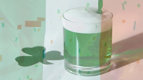 green beer in a glass with confetti falling on the foreground