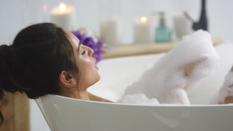 close-up view of relaxed woman blowing foam