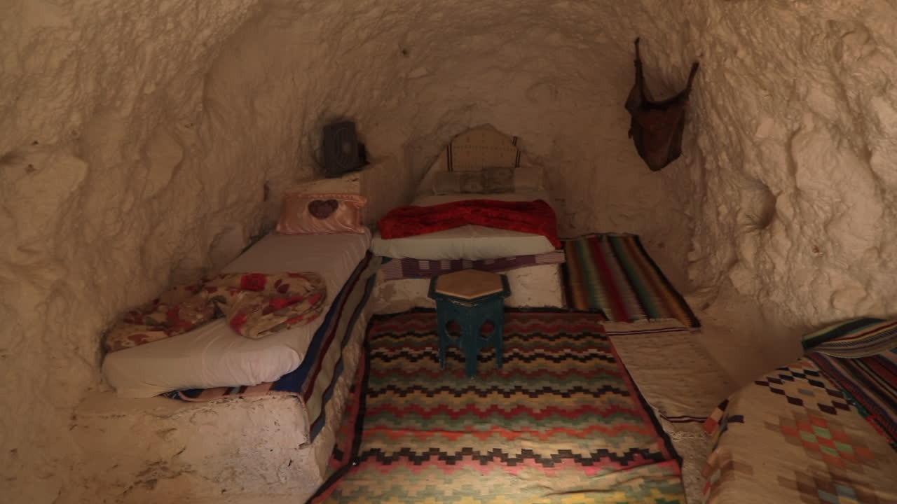 Cozy traditional cave room with colorful rugs and simple decor in Ksar Road, Tunisia