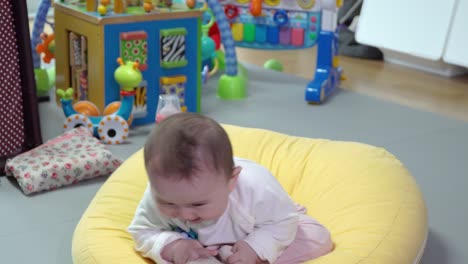 Happy-baby-girl-slapping-hands-on-legs-and-smiling-at-camera-while-sitting