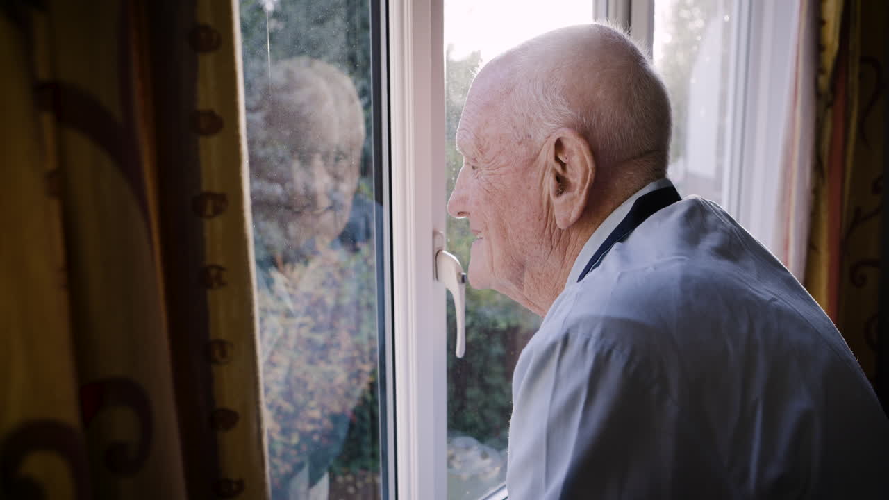 Elderly man looking out the window