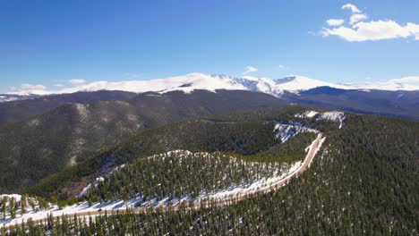 Toma-Aérea-De-La-Carretera-Del-Monte-Evans-Cerca-Del-Famoso-Punto-De-Referencia-De-Las-Montañas-Rocosas-De-Colorado-Con-Picos-Nevados-En-El-Fondo