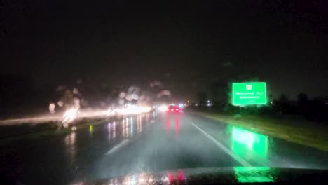 an intense view of a nighttime drive on a rainy highway, with blurred lights reflecting on the wet road. perfect for content related to night photography.