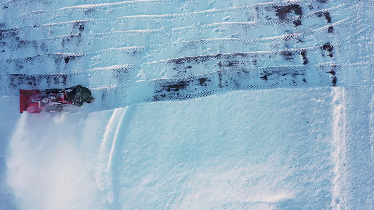 persona quita nieve con soplador de motor en un día frío, vista aérea de arriba hacia abajo