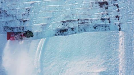 person plow snow with engine blower on cold day, aerial top down view