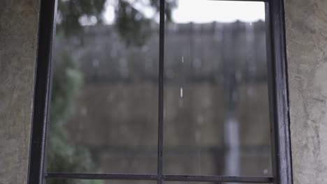 high quality 4k video of the falling rain in the falling sky, seen from the glass window slowly at close range, seasonal daytime rain.