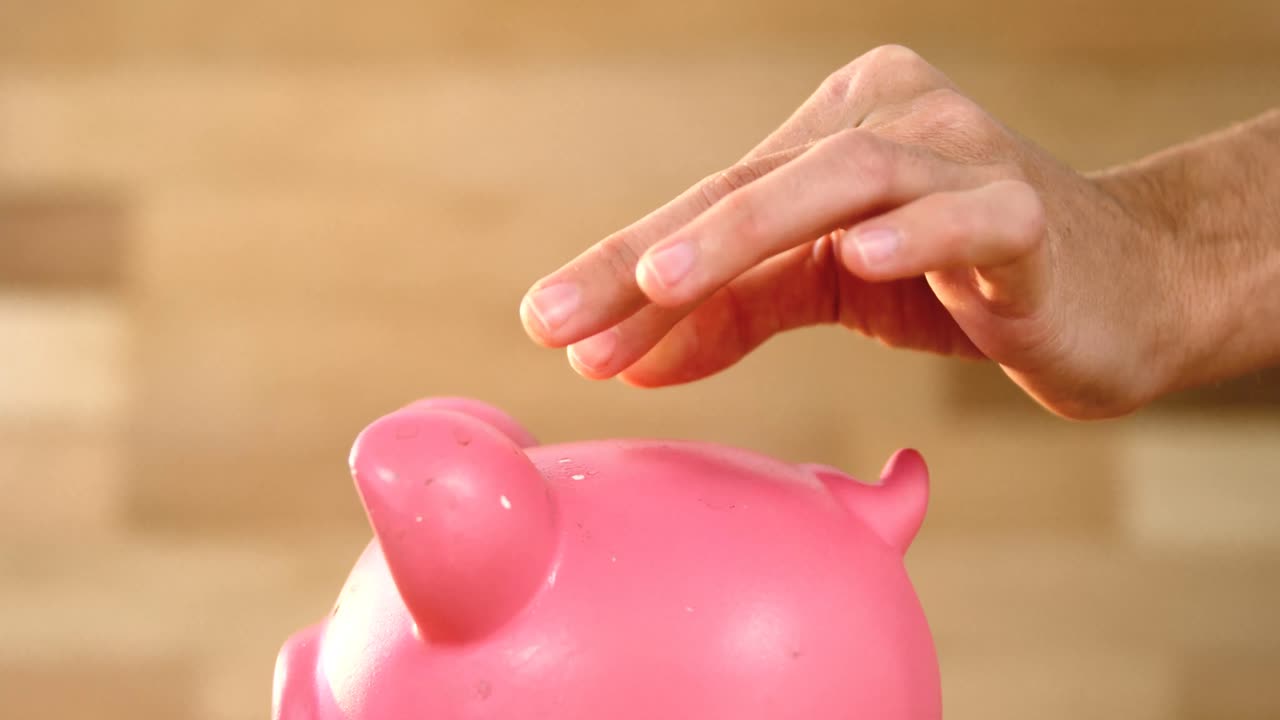 Woman putting coin in piggy bank