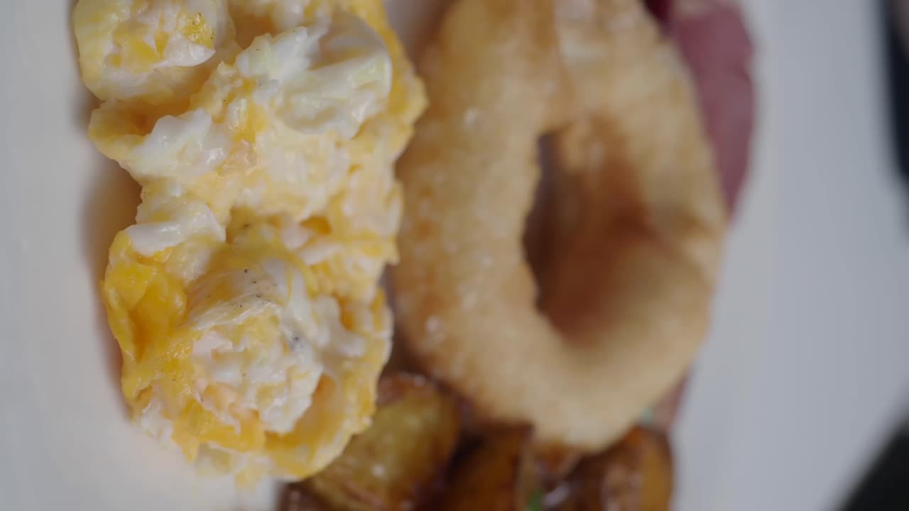 Piatto per colazione con uova strapazzate, bagel e bacon
