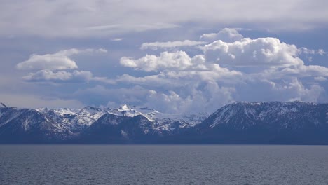 Hermoso-Lapso-De-Tiempo-De-Formaciones-De-Nubes-De-Tormenta-Que-Se-Elevan-Detrás-Del-Monte-Tallac-Cubierto-De-Nieve-Y-El-Desierto-De-Desolación-Cerca-Del-Lago-Tahoe,-California