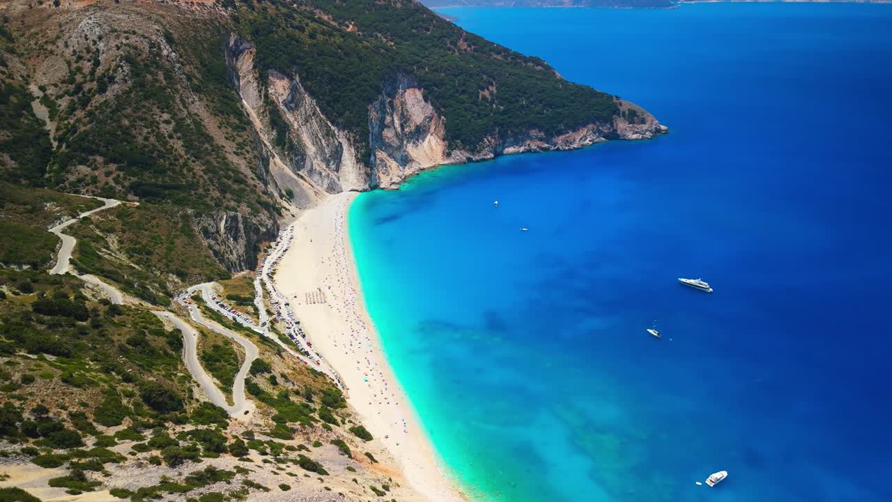 Drone Aerial and Cinematic View of the Myrtos Beach in Kefalonia. One of the most spectacular beaches in Greece and the Mediterranean. Surrounded by steep cliffs and lush green hills. DJI MINI 4PRO