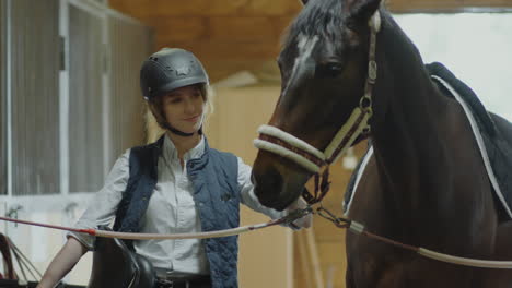 female stable worker petting horse