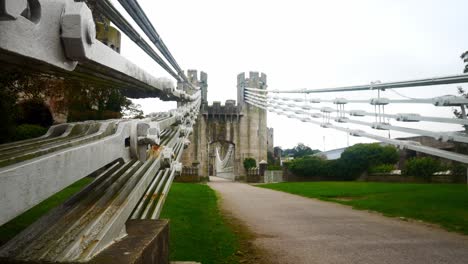 conwy castle huge steel engineering bridge cables low angle along pathway dolly left