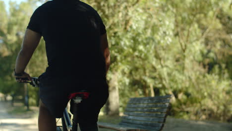 Back-view-of-man-with-disability-cycling-in-public-park