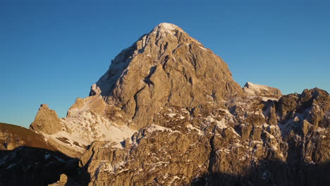 rotating cinematic aerial shot of the sun on the mangart mountain in the julian alps in slovenia