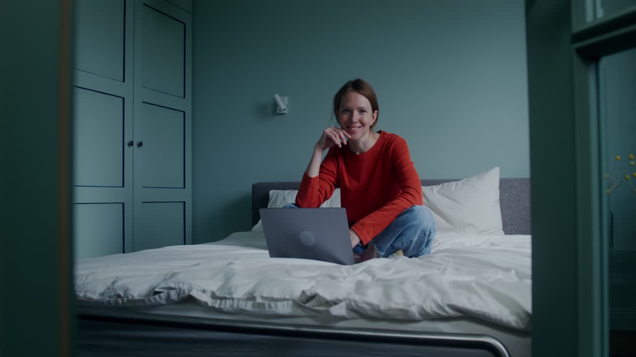 침실에서 노트북으로 집에서 일하는 여자