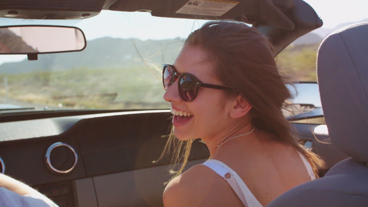 pasajera femenina conduciendo en un coche descapotable filmado en r3d