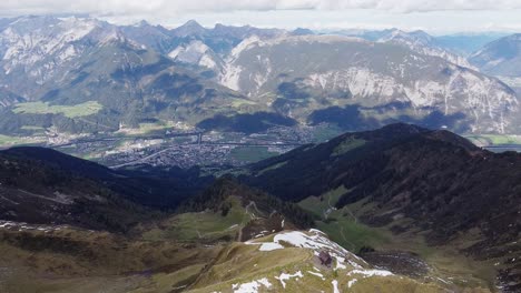 Filmische-Luftaufnahme-Des-Alpengipfels-Mit-Alter-Holzkapelle-Auf-Steilem-Gipfel