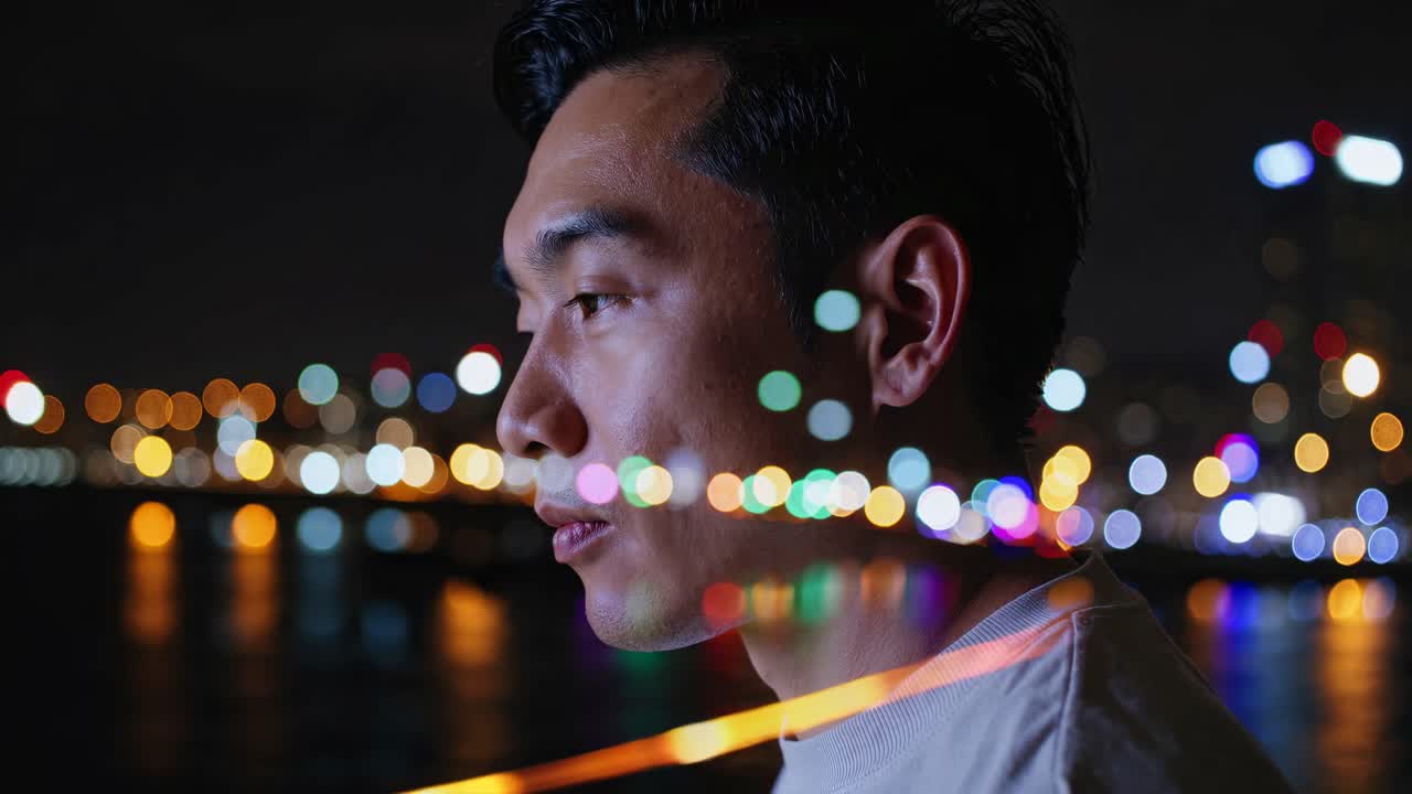 Side profile of a man with city lights bokeh overlay, shot at night