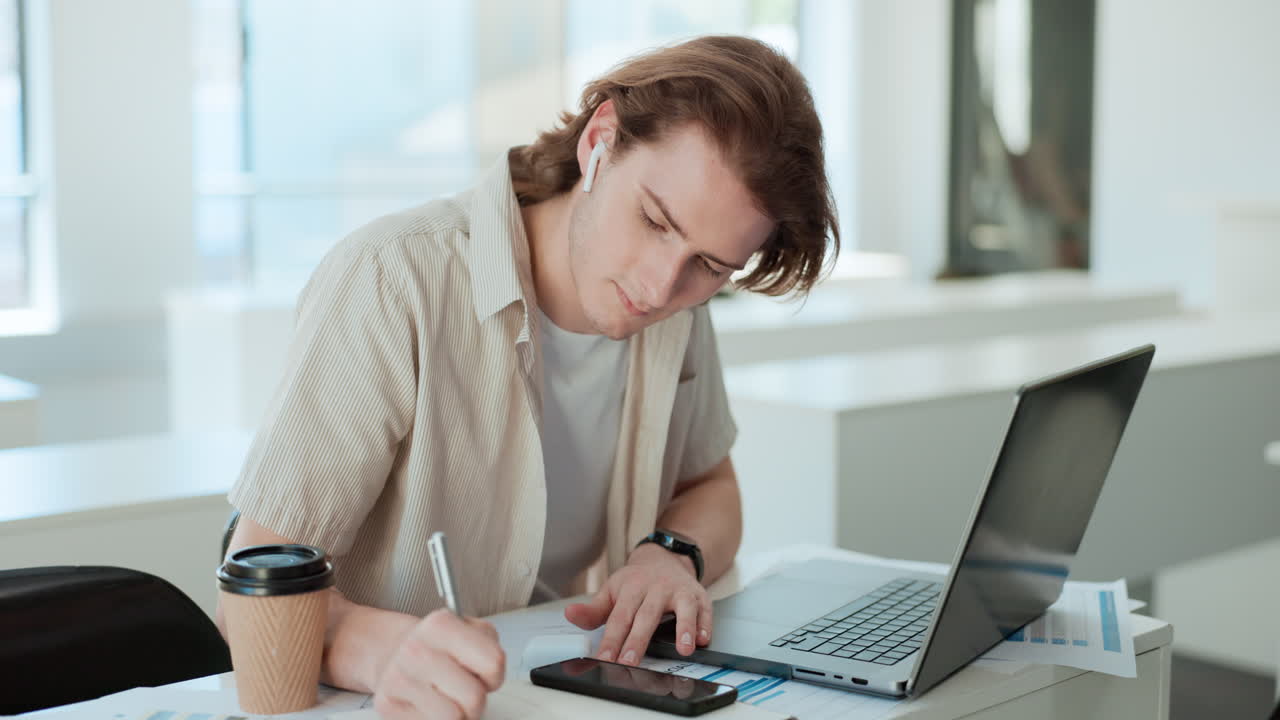 estudiante trabajando en una computadora portátil y tomando notas