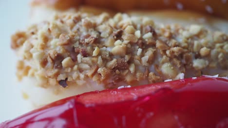 close up of glazed donuts with sprinkles and nuts