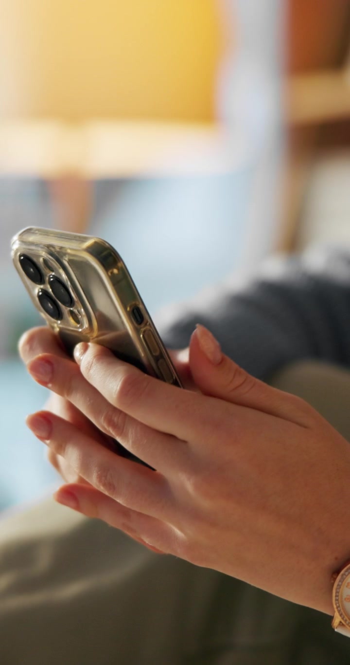 Primo piano di una donna che usa lo smartphone in un ambiente interno