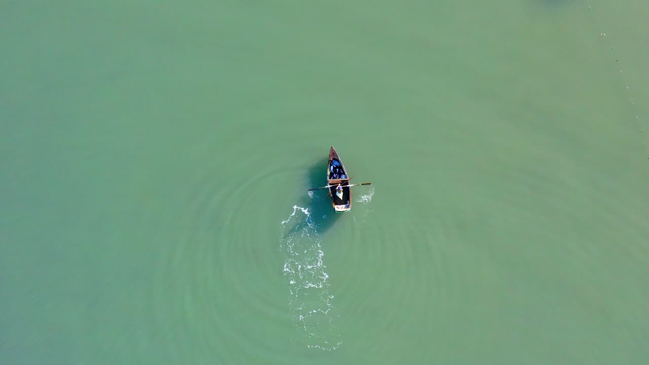 pescador aislado e irreconocible remando en un bote pequeño en aguas tranquilas del mar o del río, república dominicana