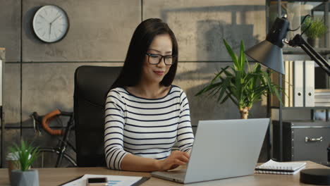 Mujer-Joven-Y-Guapa-Que-Trabaja-En-La-Computadora-Portátil-En-La-Sala-De-La-Oficina-Y-Tiene-Videochat-A-Través-De-La-Cámara-Web