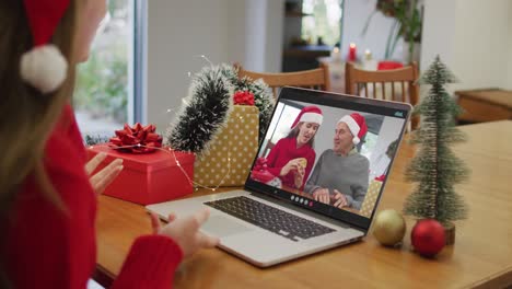Happy-caucasian-woman-on-video-call-with-grandparents-at-christmas-time