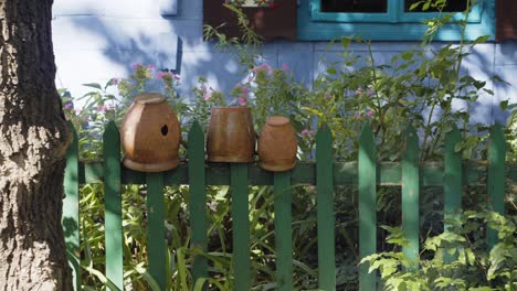 ollas de barro en la valla de madera