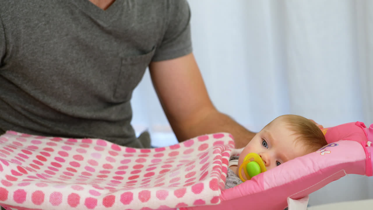 pai colocando seu bebê para dormir na cama do bebê 4k