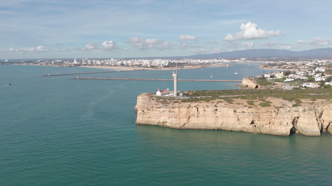 Vista aerea panoramica che mette in risalto il faro, le scogliere frastagliate e l'ampio oceano nel sud del Portogallo