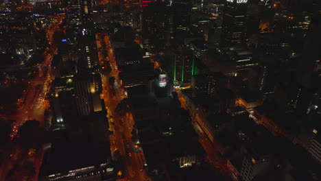 High-angle-view-of-orange-illuminated-streets-in-night-city.-Fly-above-blocks-of-buildings-divided-by-rectangle-road-network.-Cape-Town,-South-Africa