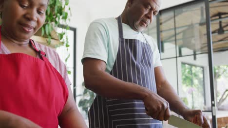 happy african american senior couple cooking together in kitchen