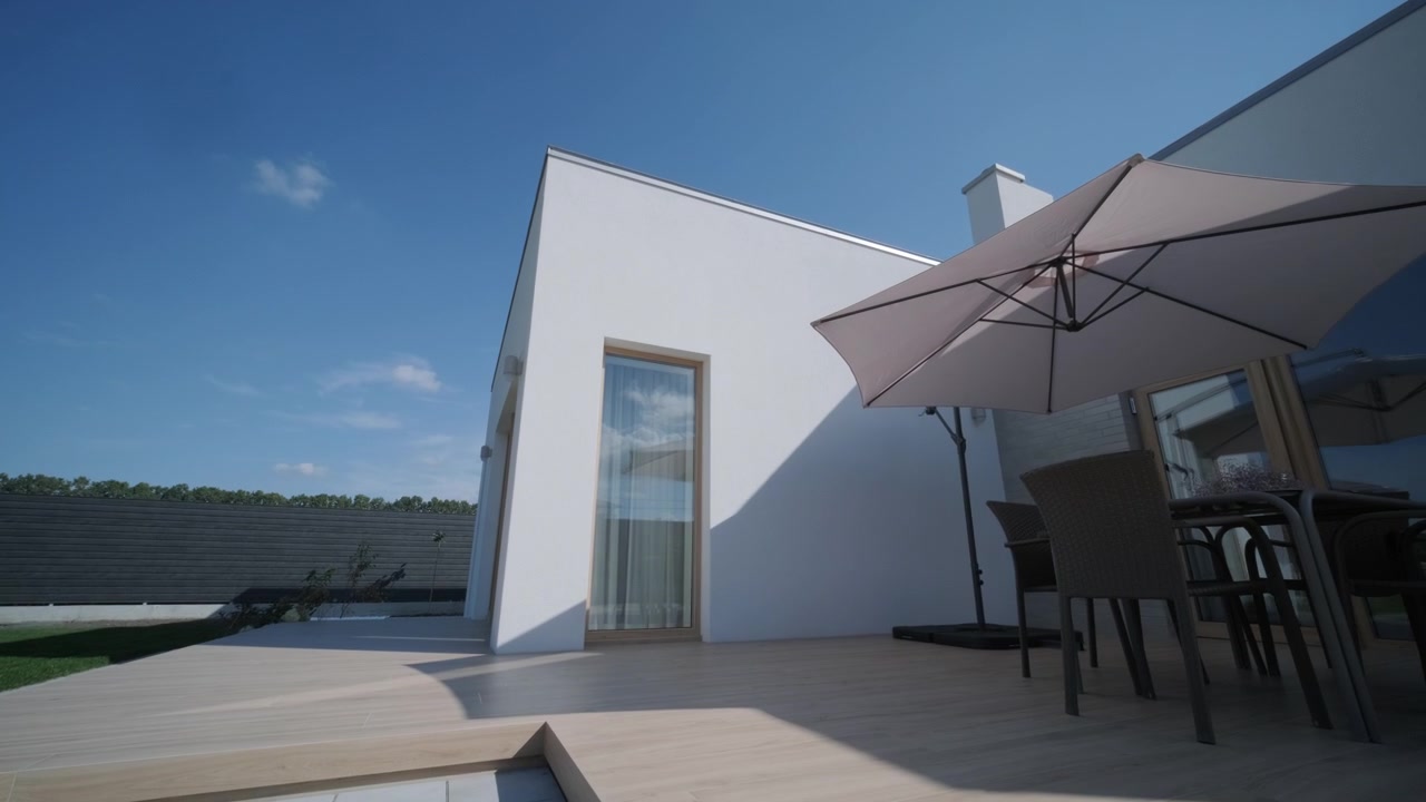 Esterno di una casa moderna con terrazza in legno e mobili da giardino