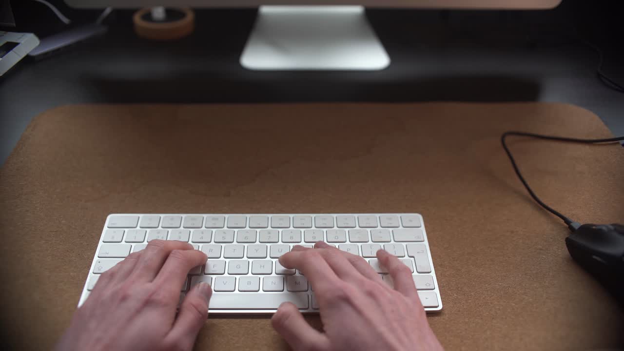 Man working behind his desk typing on his keyboard