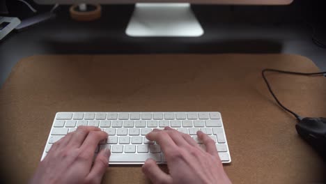 Hombre-Trabajando-Detrás-De-Su-Escritorio-Escribiendo-En-Su-Teclado