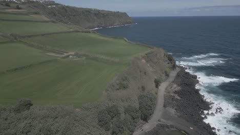 Green-meadows-on-high-cliffs-along-rocky-coast-of-Santo-Antonio,-Sao-Miguel-island