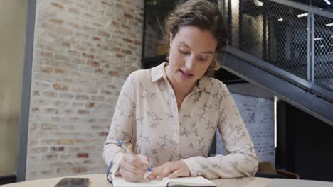 caucasian casual businesswoman making video call in office lounge, slow motion