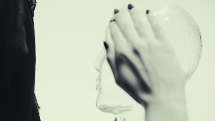 Woman's hand near a transparent mannequin head