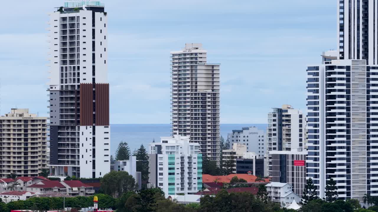 Drone footage captures Gold Coast's towering skyscrapers against a serene ocean backdrop, highlighting urban architecture and coastal beauty