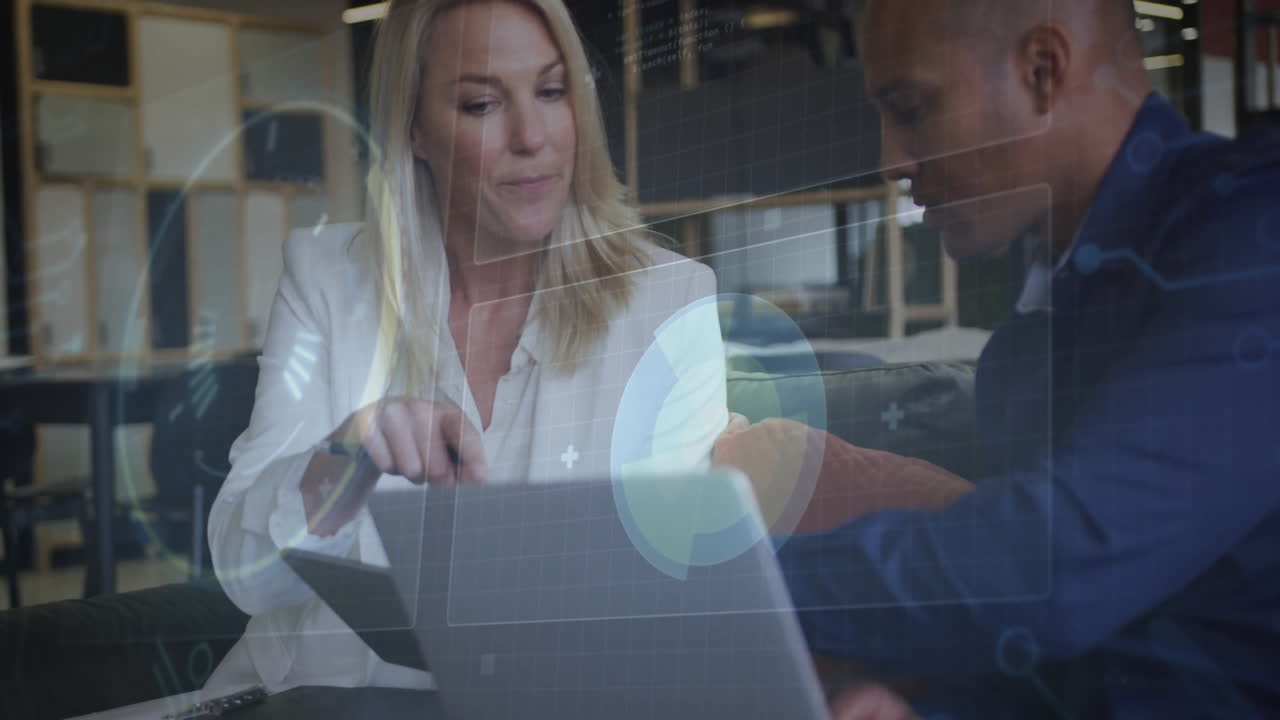 woman pointing stylus at tablet while man leaning forward in office, tech data overlays floating