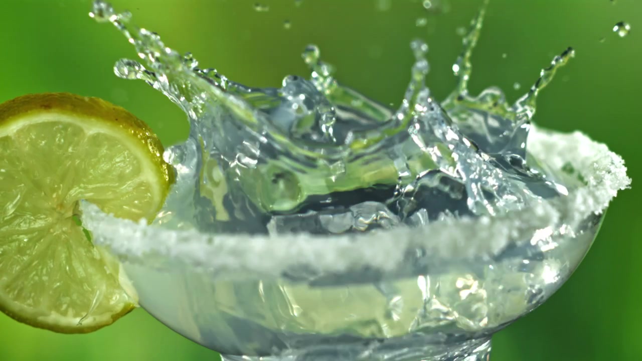 Slow Motion Ice Cube Splashing into Margarita Glass with Lime