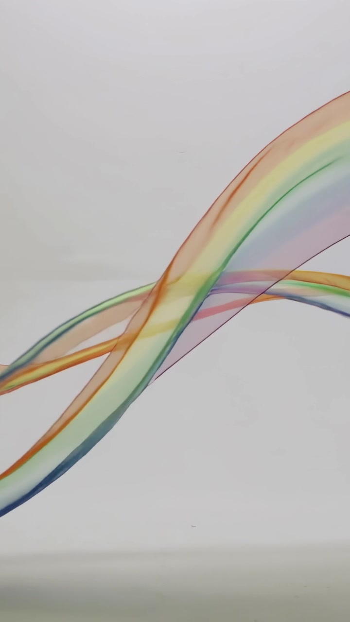 Vertical video: Entering right, translucent ribbons sweeping, weaving on light backdrop mixing hues
