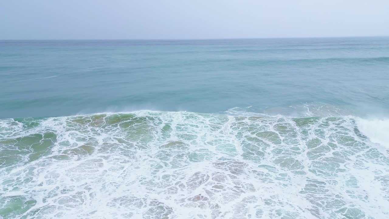 Waves crashing on the shore in slow motion at Aljezur, Portugal, captured from above