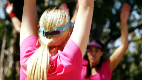 Female-trainer-assisting-women-while-exercising-in-the-boot-camp