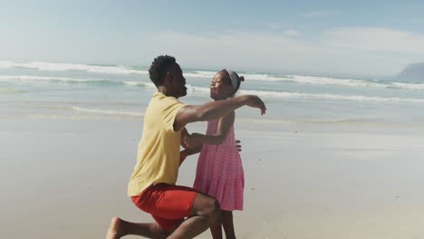 padre y hija afroamericanos abrazándose en la playa