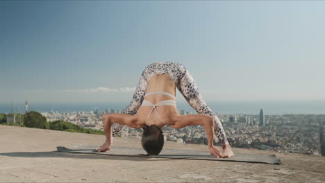 woman stretching body at viewpoint of barcelona.athletic girl doing yoga in city